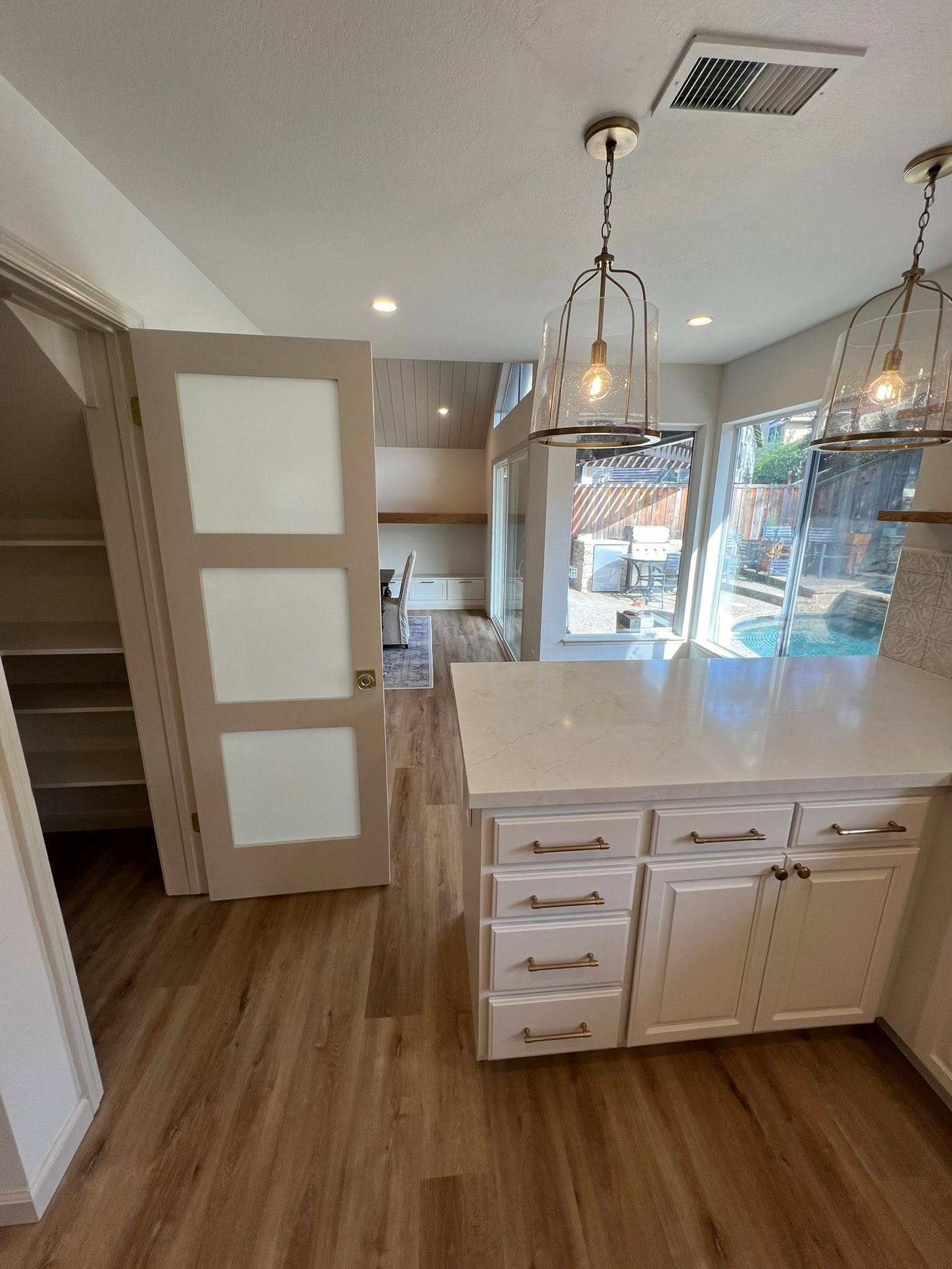 Open kitchen renovation with pendant lights — Niche Construction