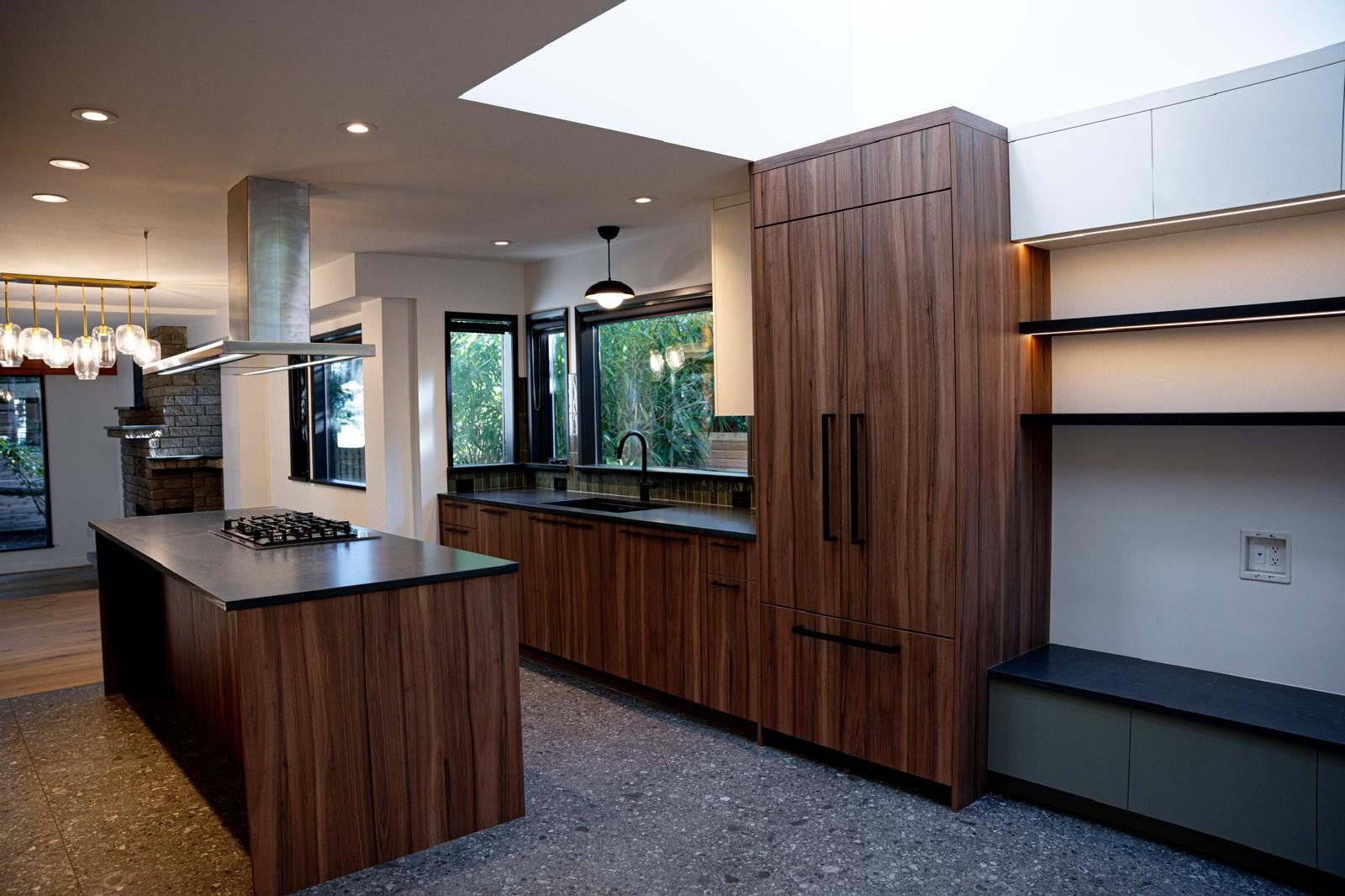 Kitchen renovation with walnut cabinets, black counters, island and skylight