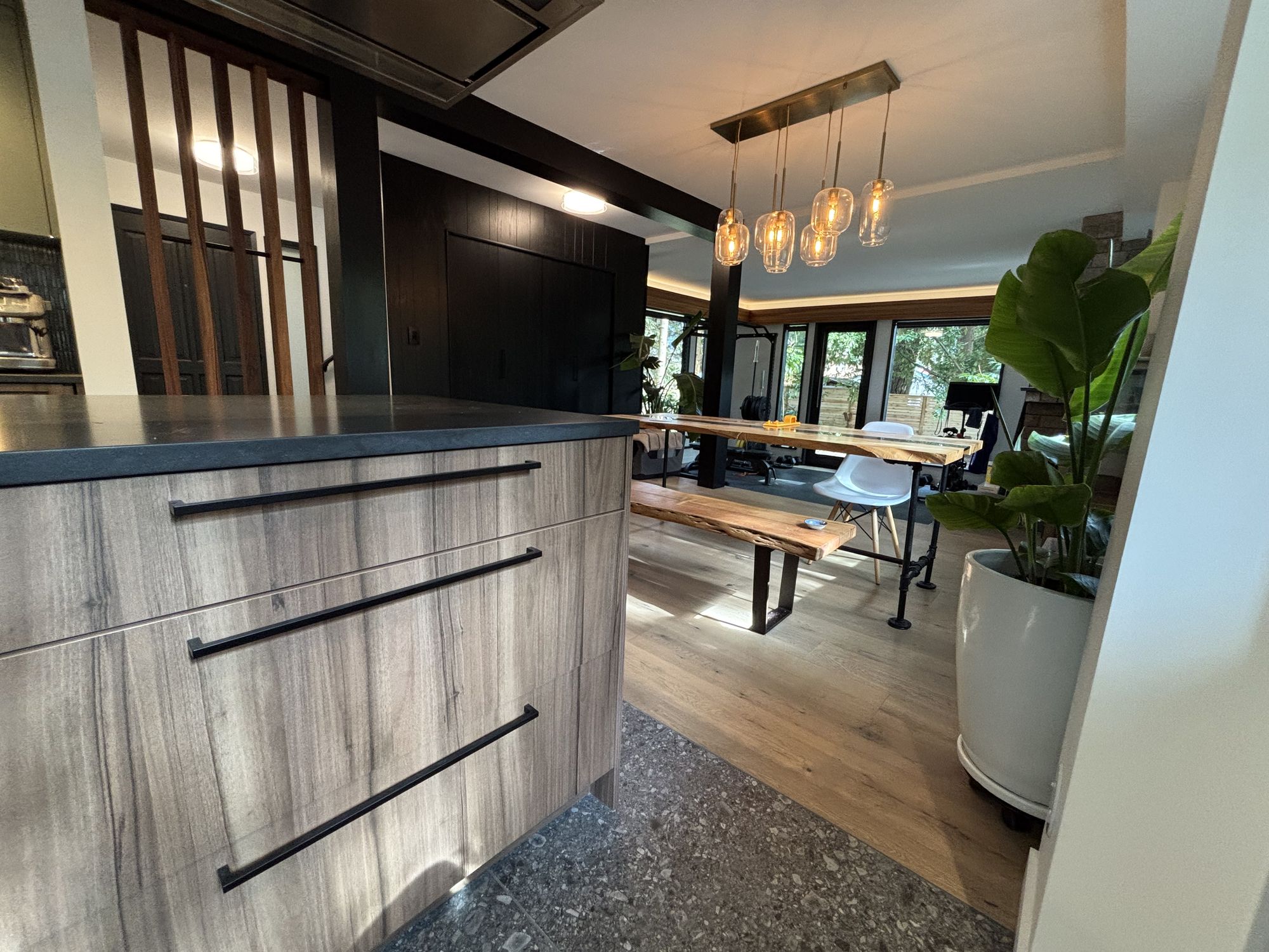 Kitchen renovation with textured wood island, black pulls and open view to the dining area