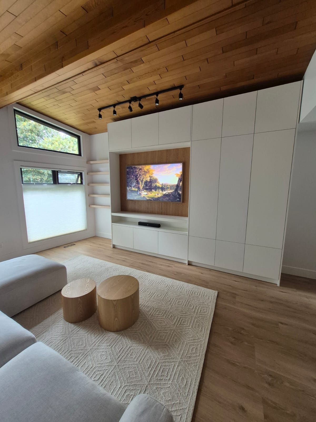 Living room with cedar ceiling and built-in white media wall
