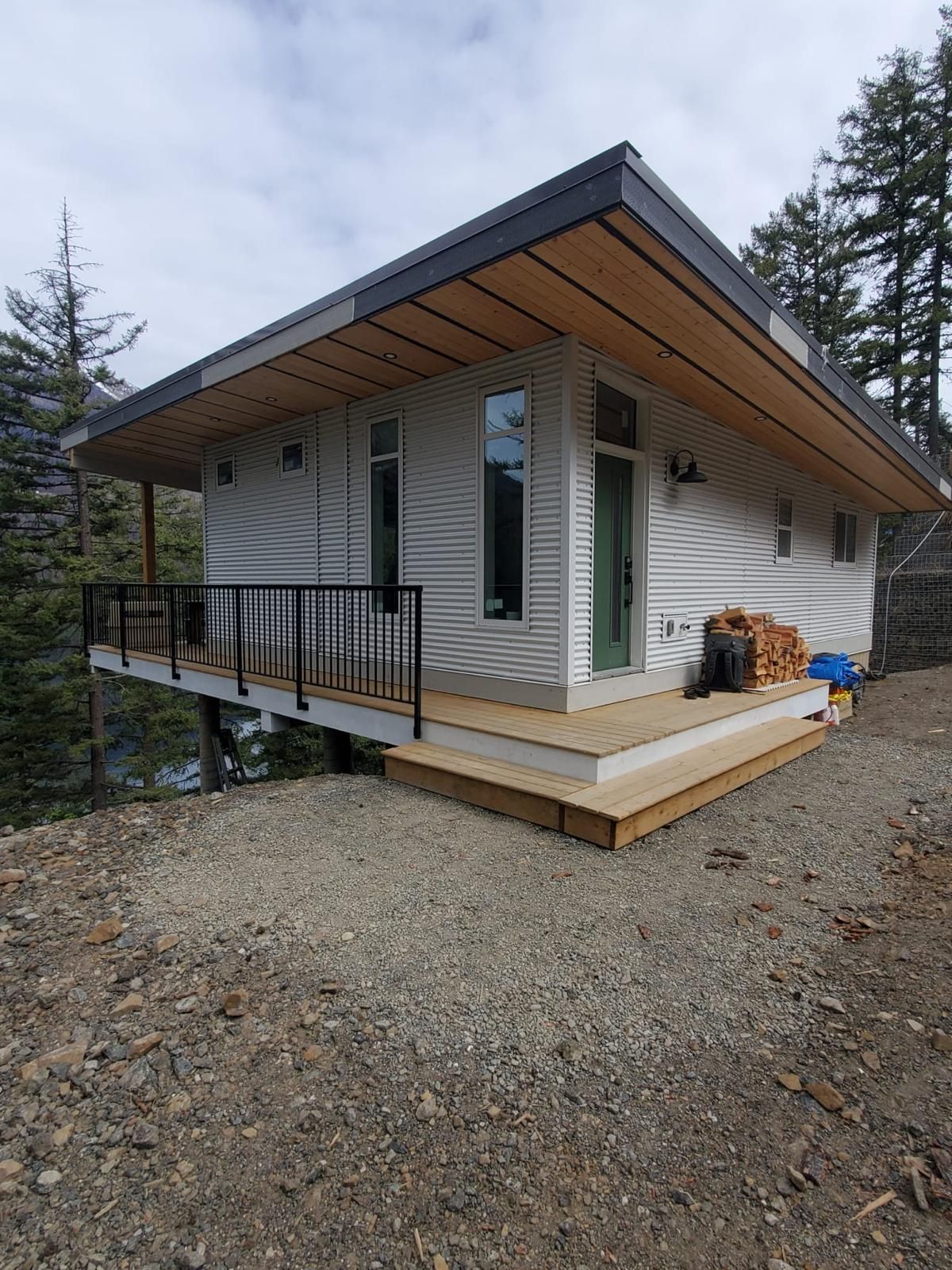 Custom mountain home with cedar deck, black railing and wide roof overhang