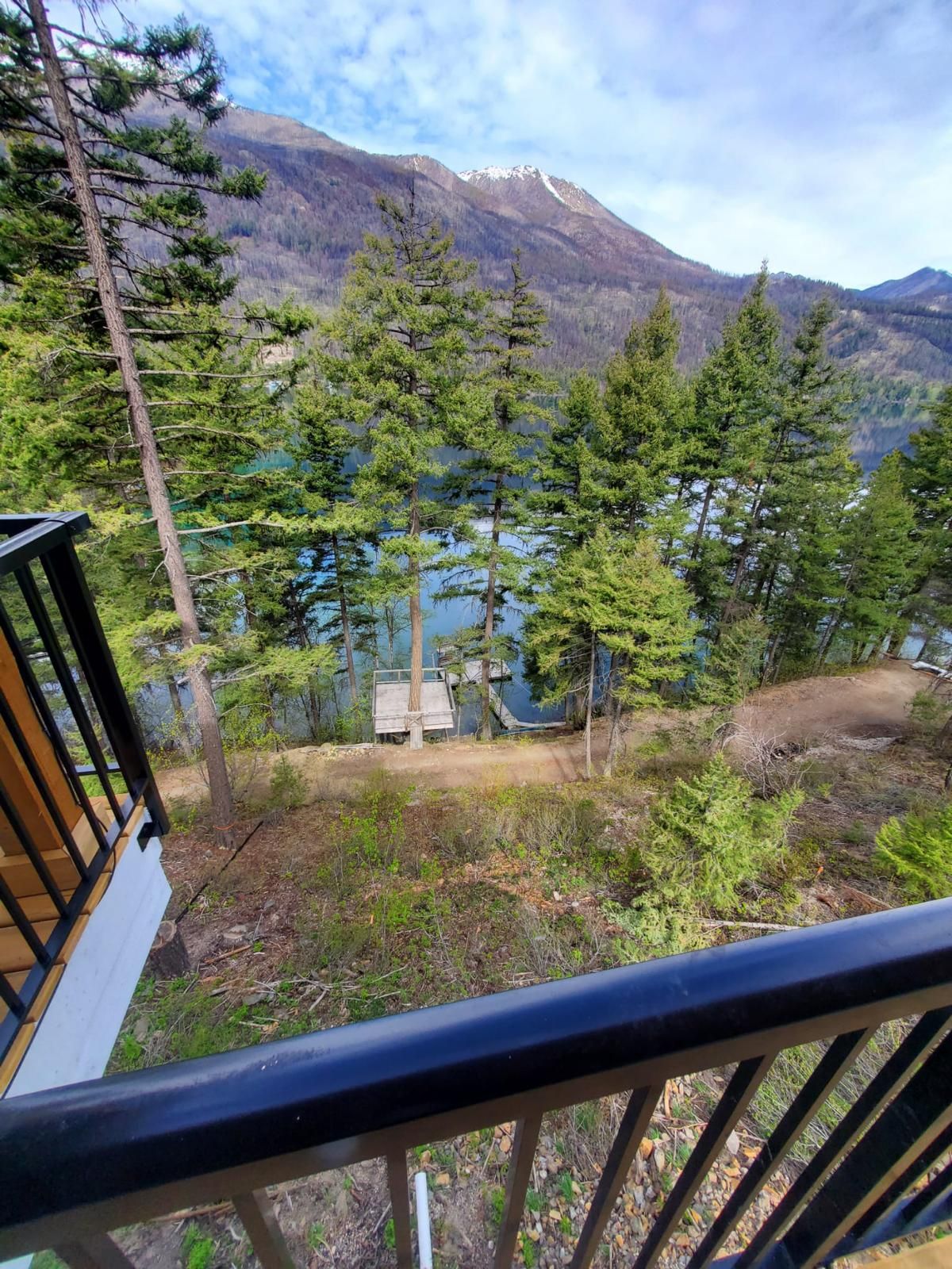 Mountain and forest view from a custom home deck with black railing
