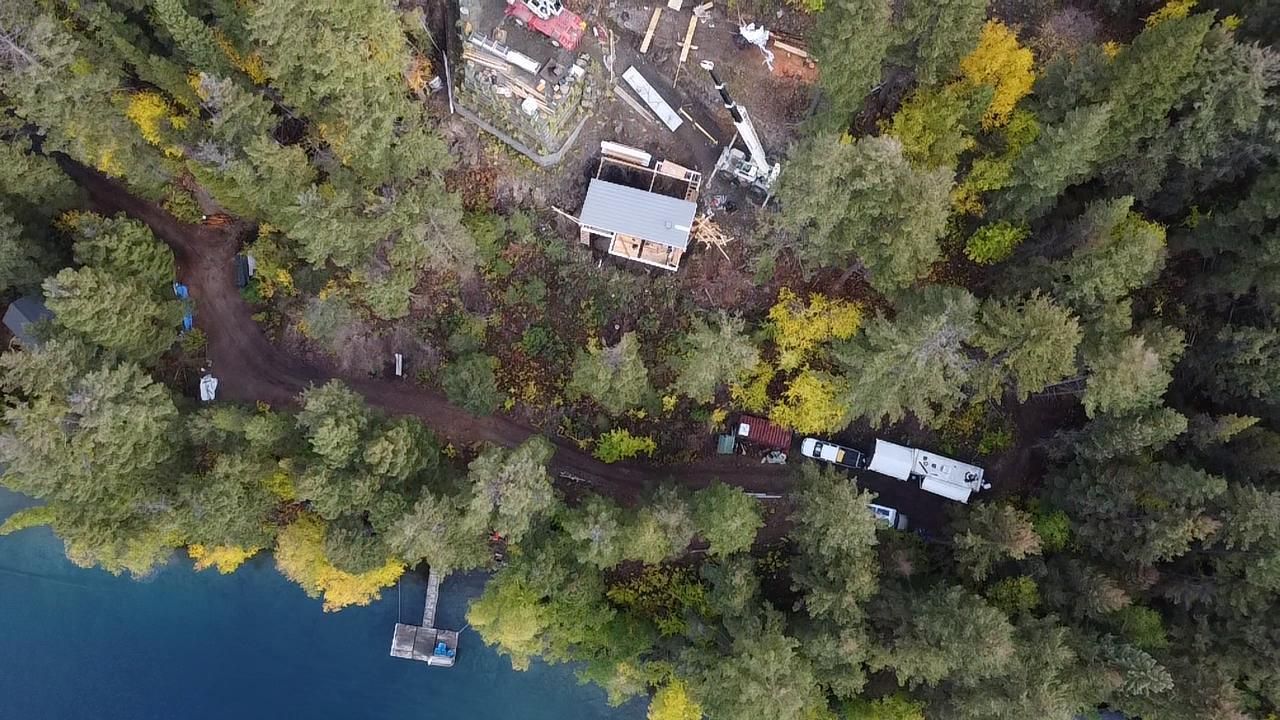 Aerial view of a Kelar Homes custom home site on a forested lakeshore