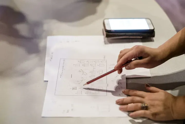 A sketchbook open with fabric swatches and a pencil