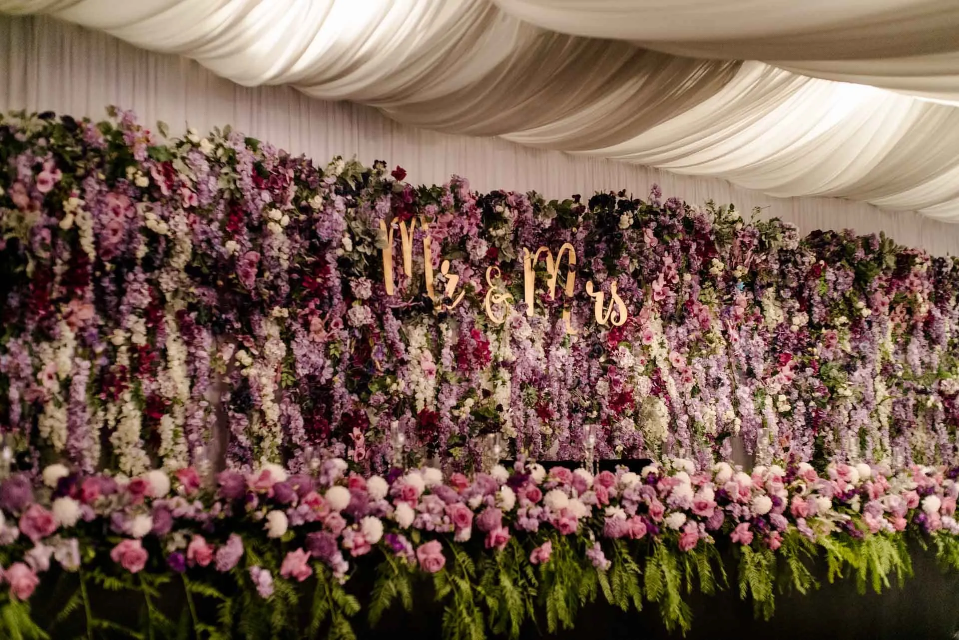 Flower wall behind a dessert table