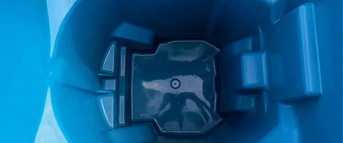 An overhead shot of the interior of an aqua blue paddle boat with a molded seat and footrests.