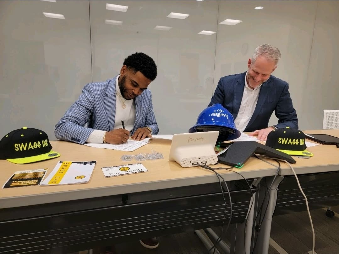 A signing at a table with Swagg Inc. hats