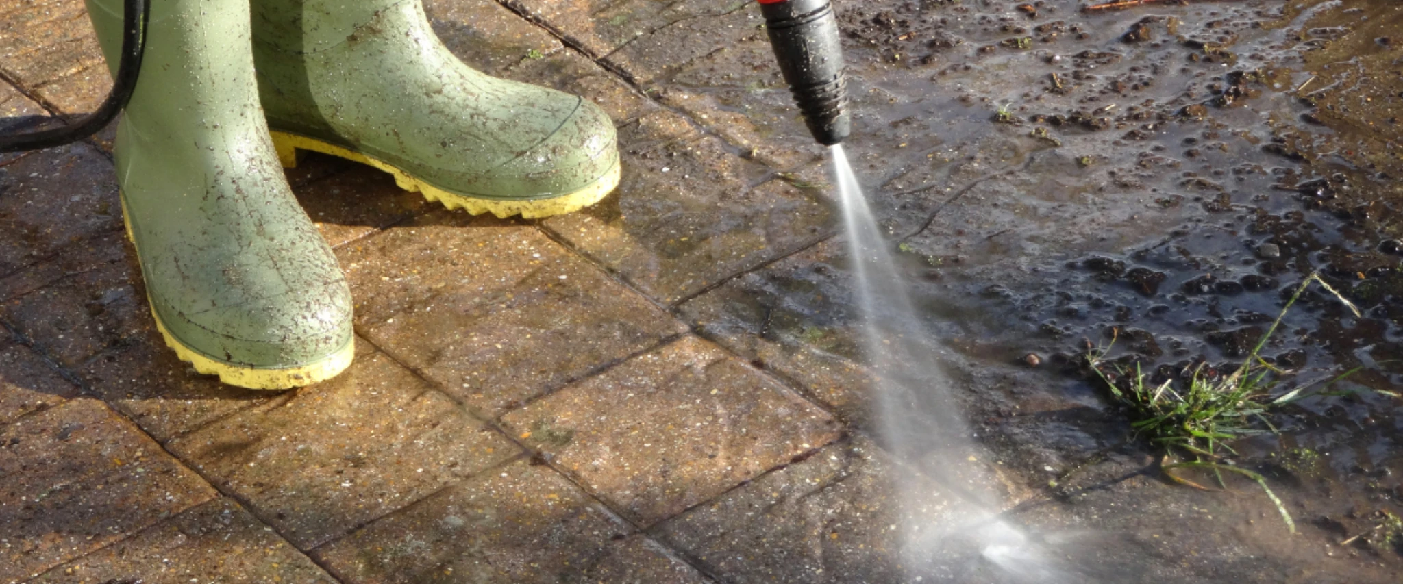ressure washing removing dirt and moss from brick paver patio surface