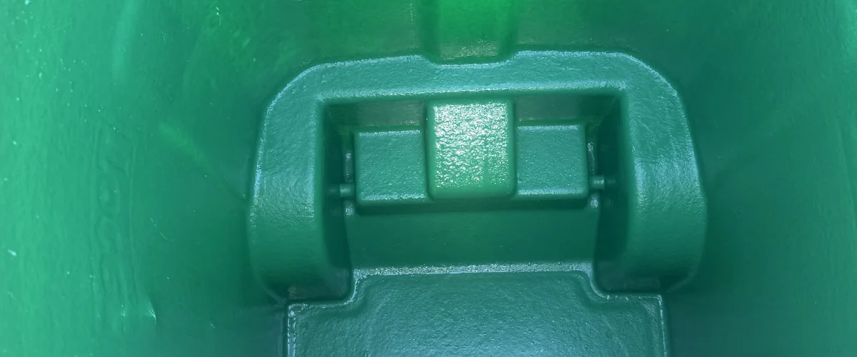 A close-up, top-down view of a textured, forest green plastic container interior with a prominent hinge mechanism. A close-up, top-down view of a textured, forest green plastic container interior with a prominent hinge mechanism.
