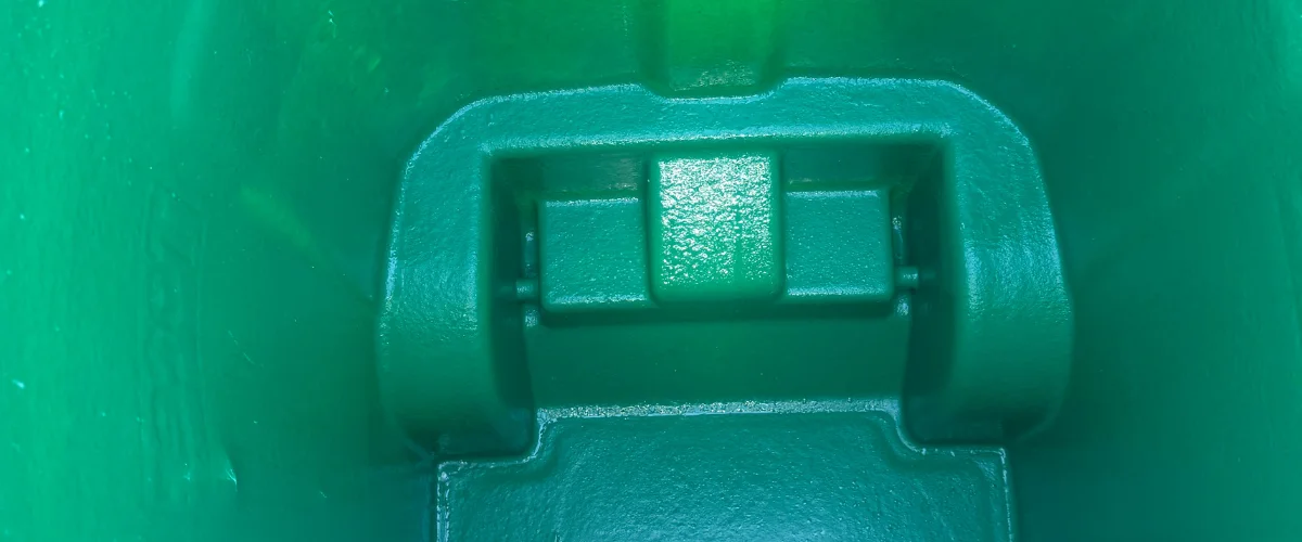 A close-up, high-angle view looking down into the interior of a textured, vibrant green plastic container or bin. A close-up, high-angle view looking down into the interior of a textured, vibrant green plastic container or bin.