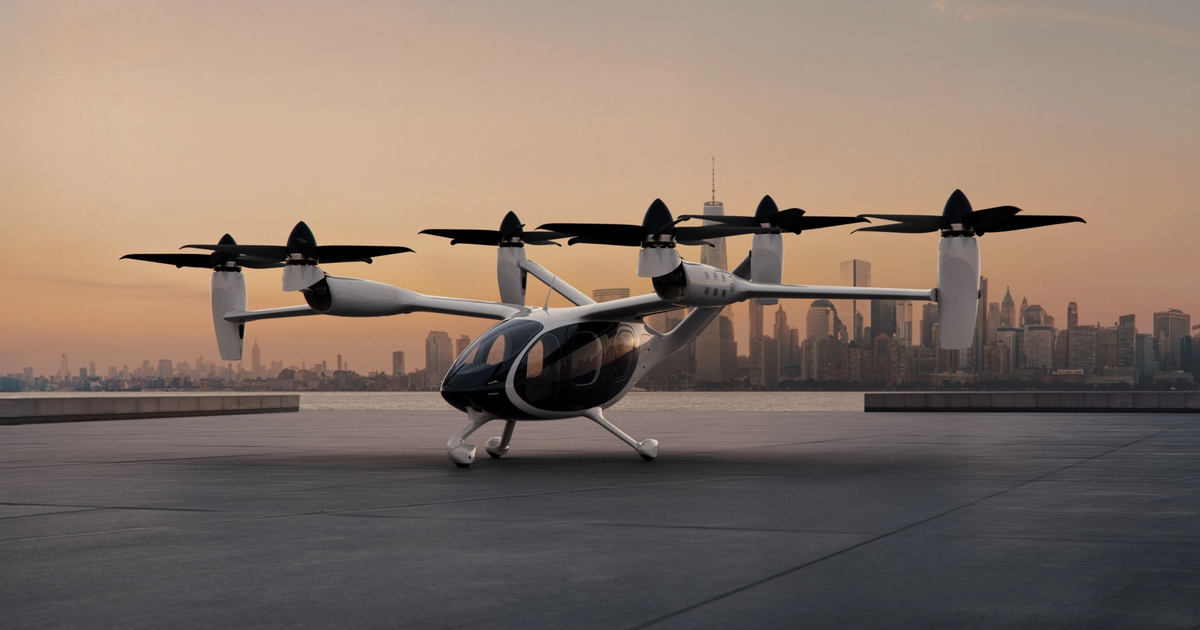 Joby Aviation electric vertical takeoff and landing (eVTOL) aircraft parked on a modern rooftop helipad in a city environment.