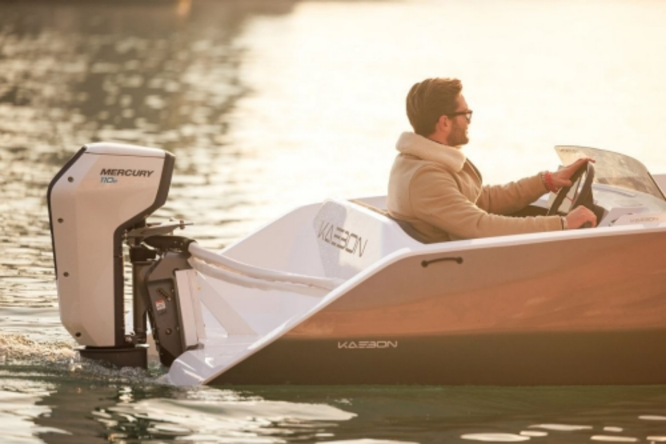 Close-up of a Mercury Avator 7.5e electric outboard motor mounted on the transom of a small boat, featuring its sleek black design and integrated tiller handle.