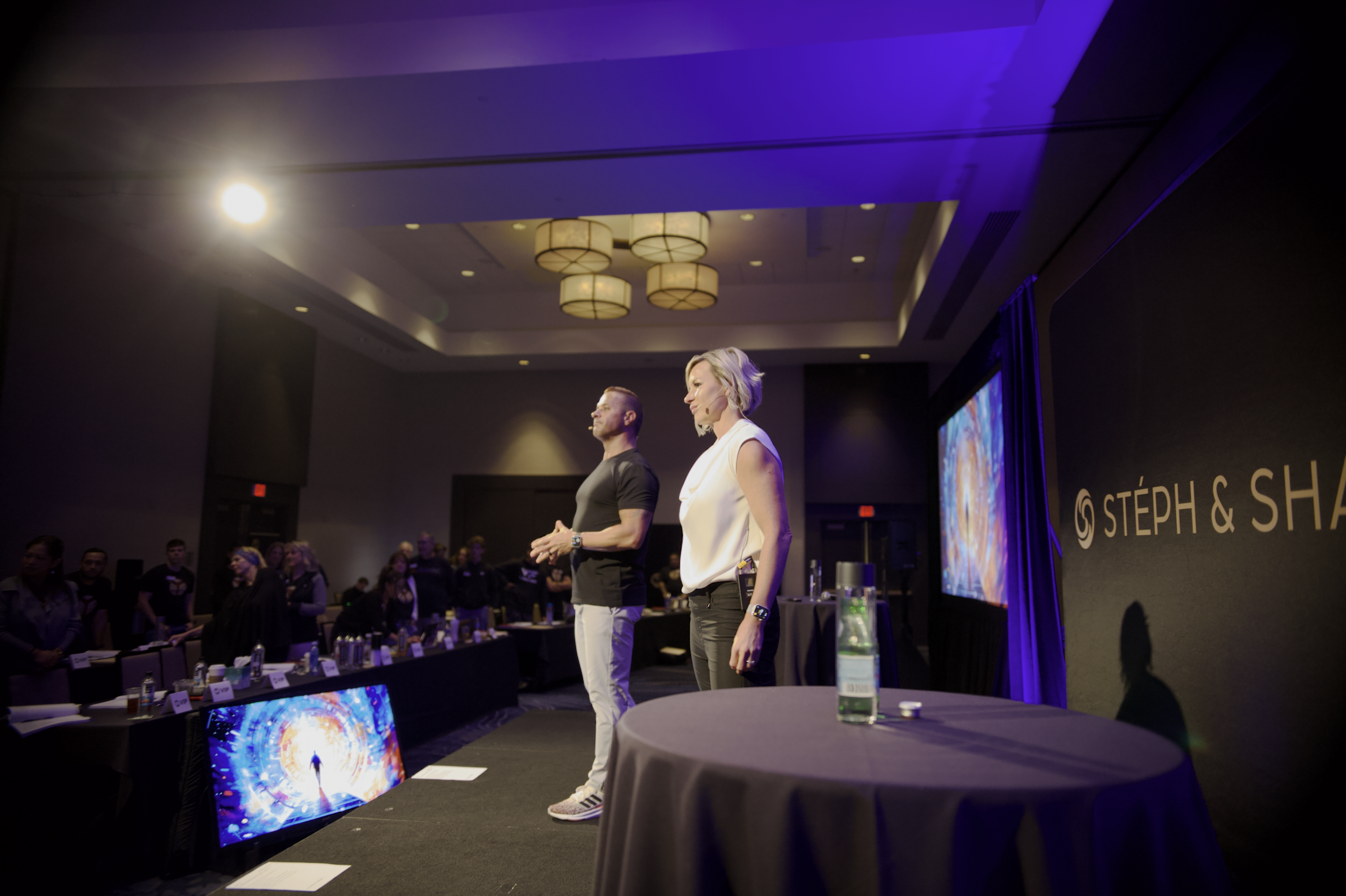 Stéph and Shay presenting on stage to coaching audience