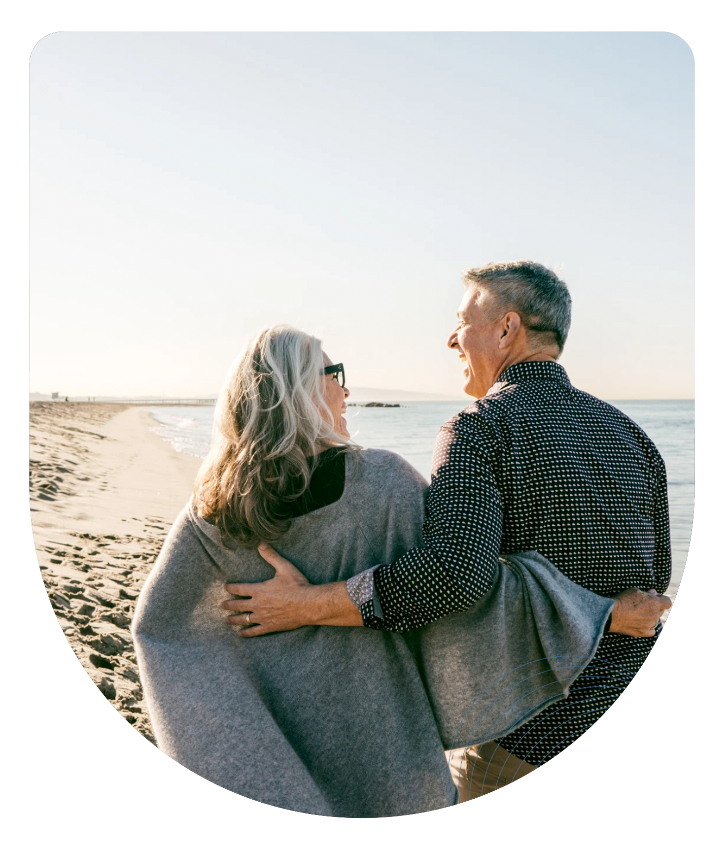 An older couple walking together on the beach