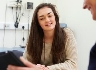 Clinician talking with a patient in a medical consulting room