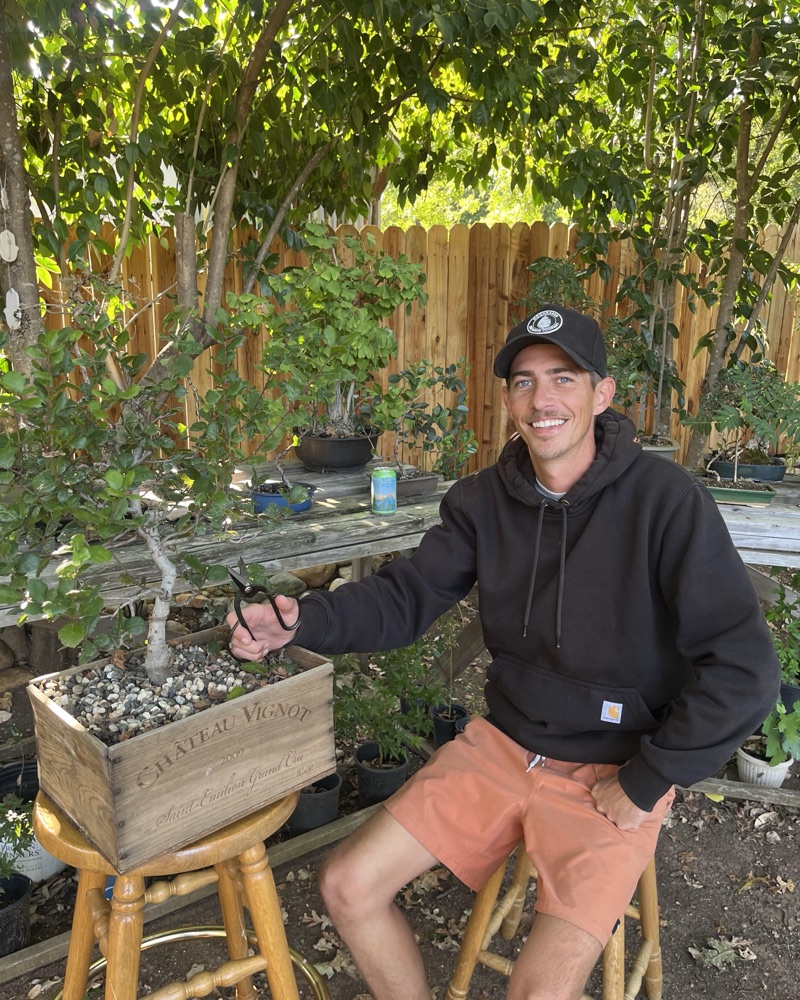 Brandon Johnson with a bonsai in his garden