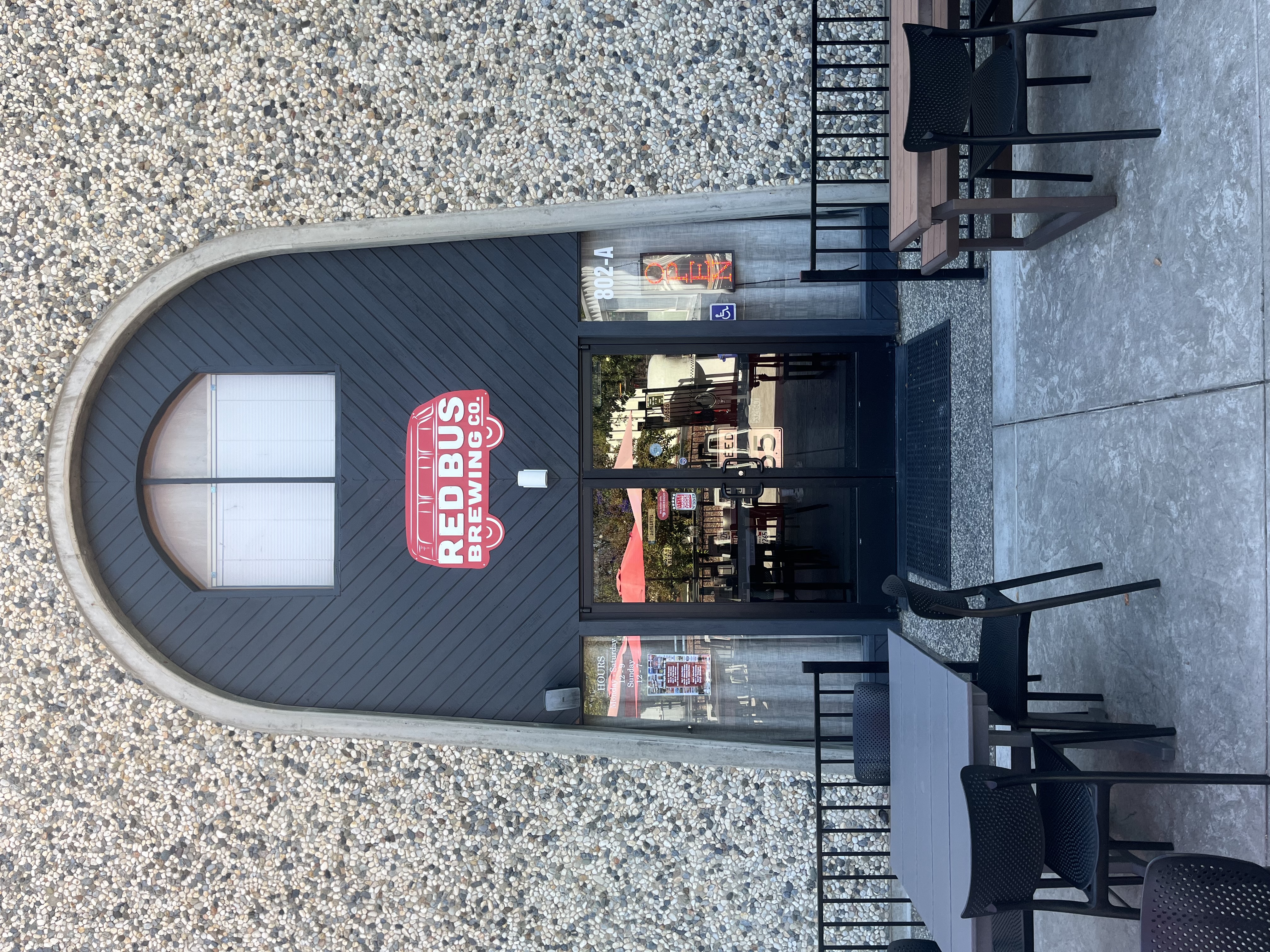 The arched entrance to Red Bus Brewing Company with its red bus sign