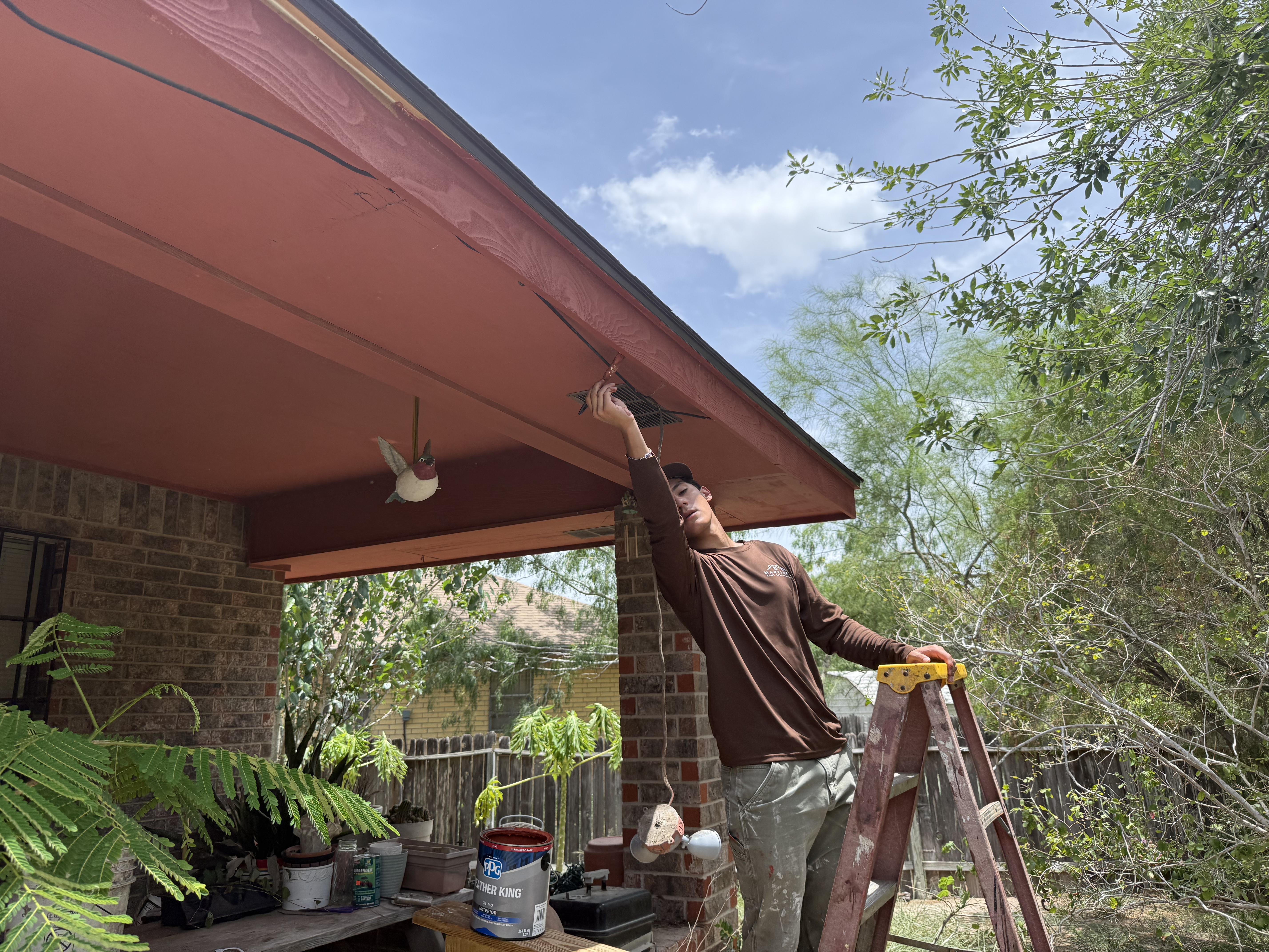 Frontline Roofing crew painting new fascia on a McAllen home