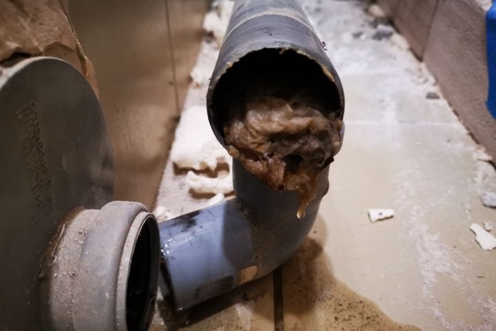 A severely clogged and overflowing drainpipe illustrating major sewer line problems.