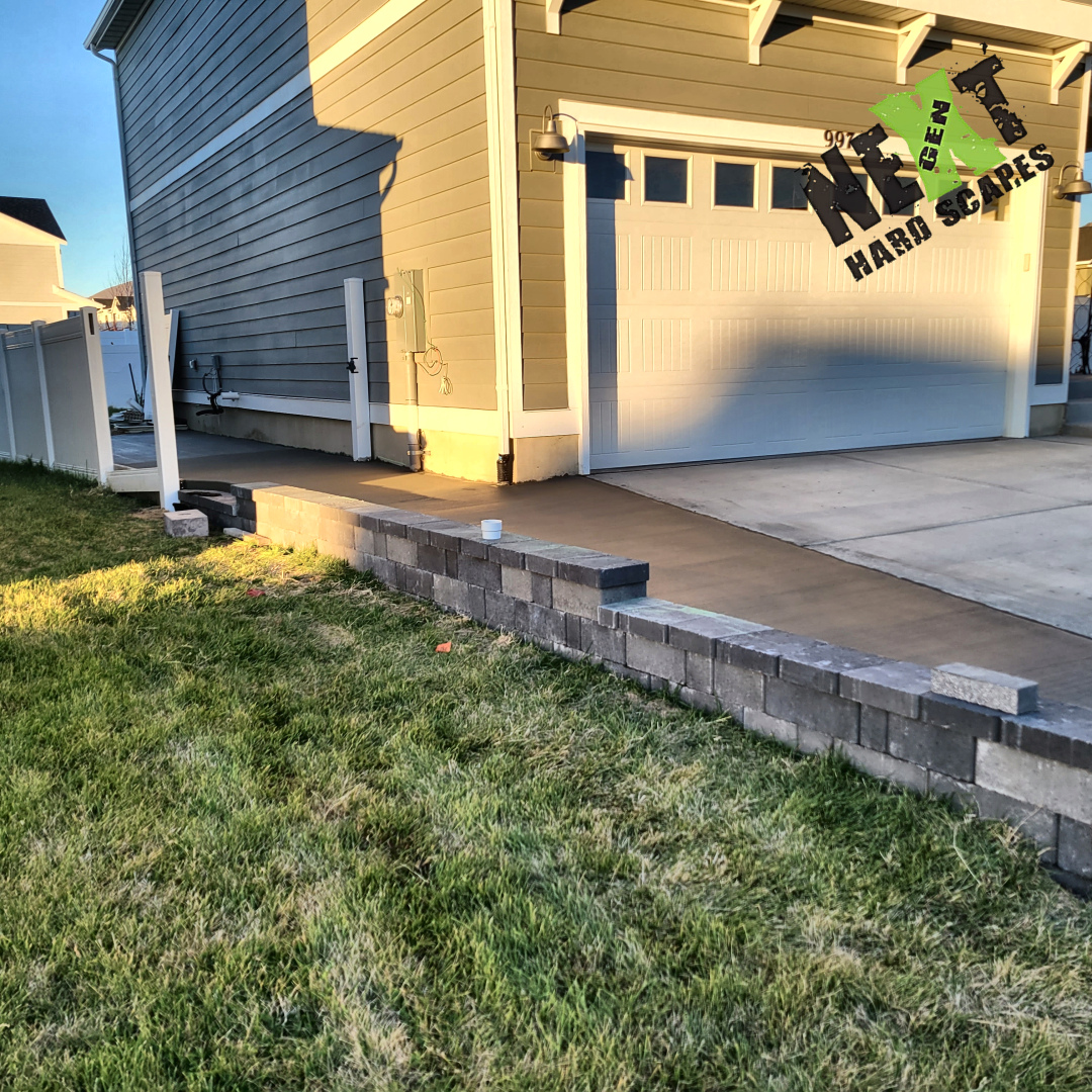 Detail of the retaining wall extending along the edge of the concrete side drive, maintaining consistent height and alignment.