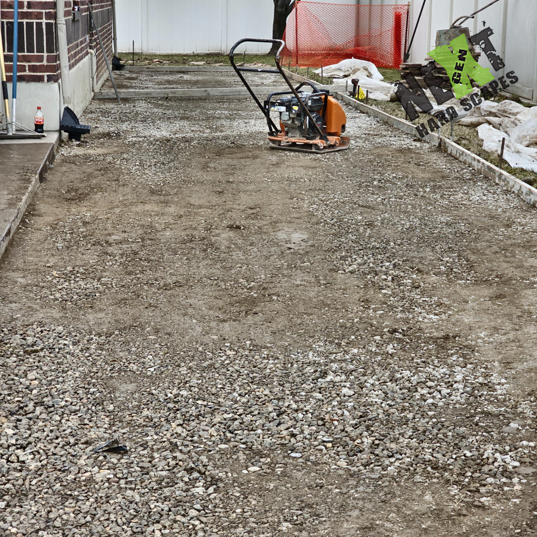 Compacted gravel base installed and leveled with edging in place, ensuring proper support and drainage for the concrete slab.