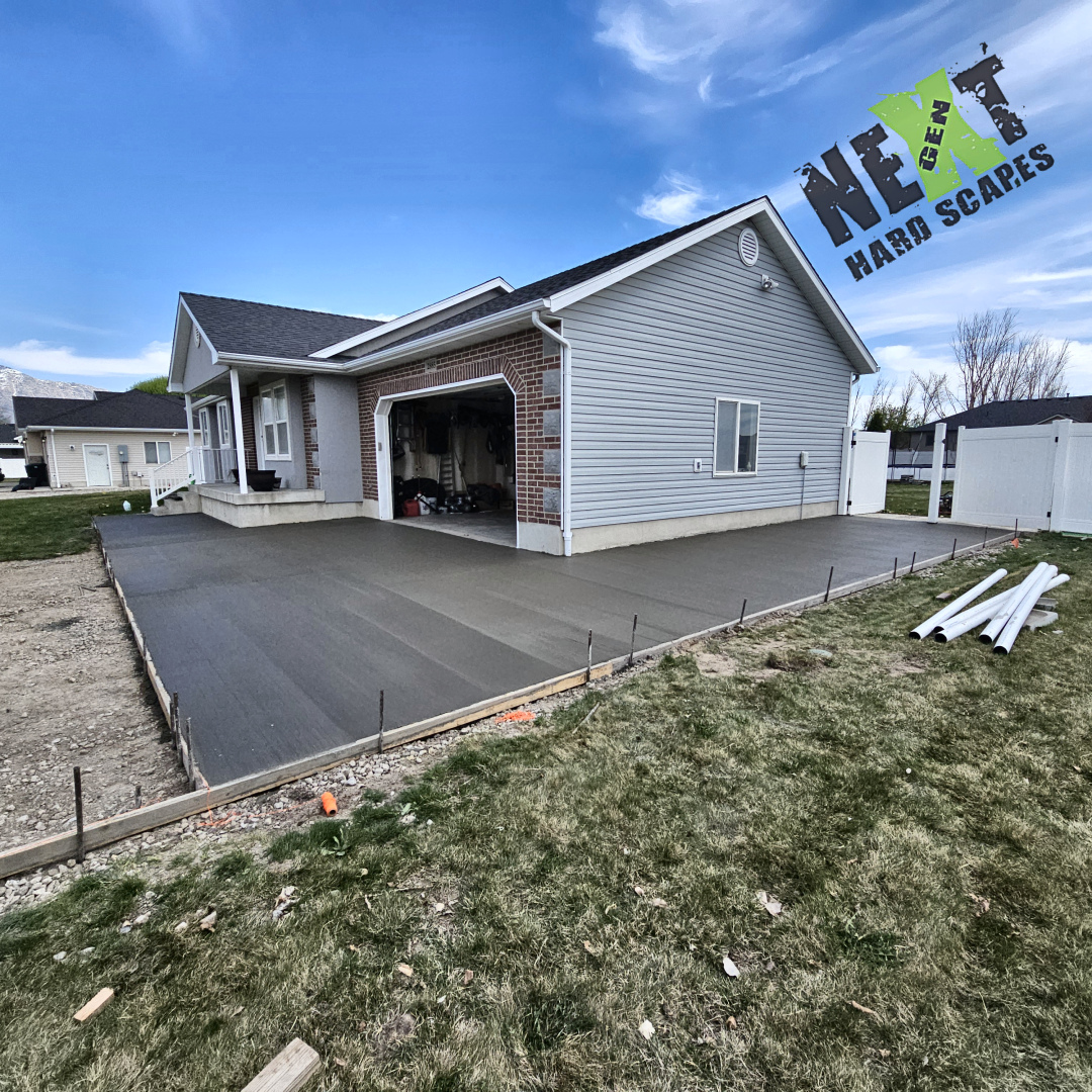 The area around the house and side driveway has been fully excavated and covered with compacted gravel, and concrete has been poured for the first part of this project.