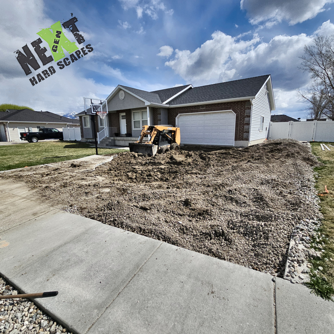 Excavation of the old driveway reaches completion as heavy equipment shapes and prepares the soil to meet grade and slope requirements.