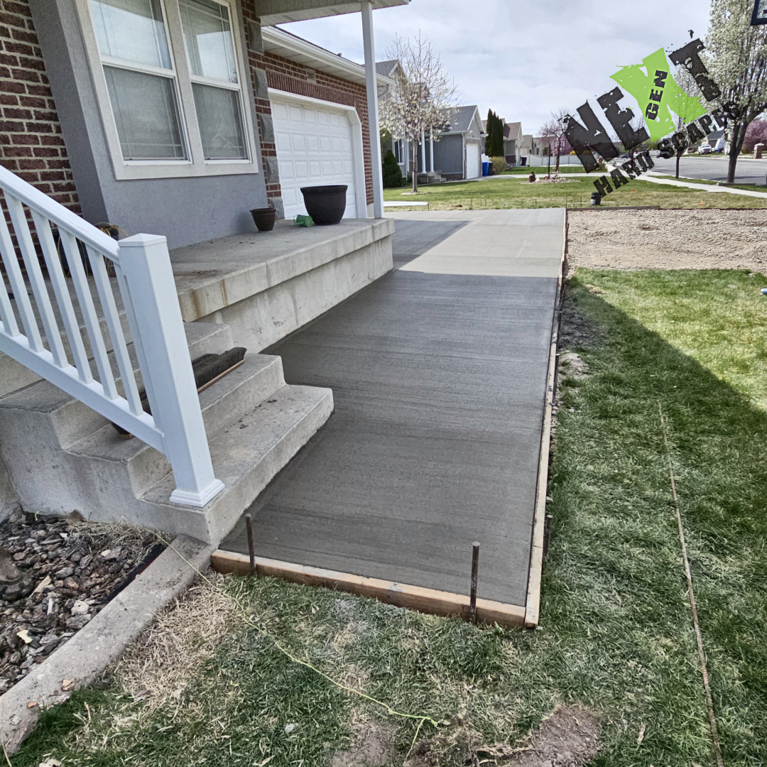 Concrete walkway alongside the house showcases meticulous finishing work, with tight joints and careful attention to surface texture near structural elements.