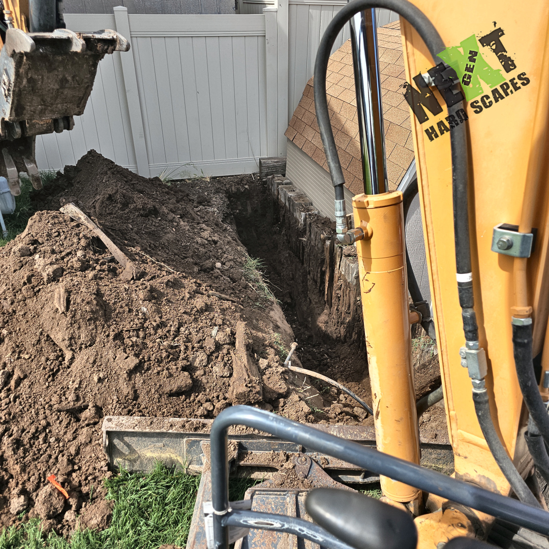 Excavation underway as we carefully remove the old railroad ties and prepare a deep, level footing for the new retaining wall.