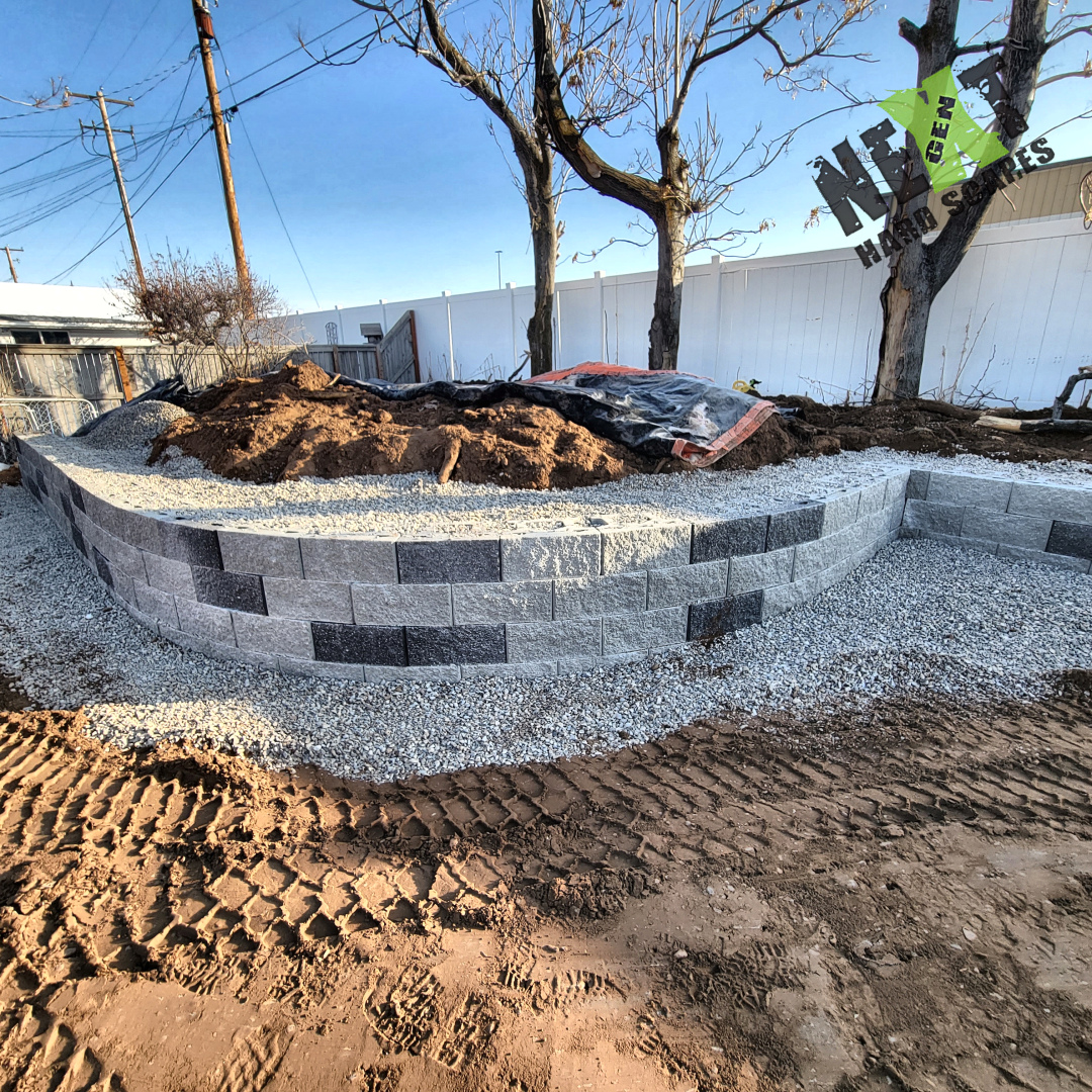 Raised garden bed framed by retaining wall blocks with compacted gravel base prepared around, ready for soil backfill. Raised garden bed framed by retaining wall blocks with compacted gravel base prepared around, ready for soil backfill.