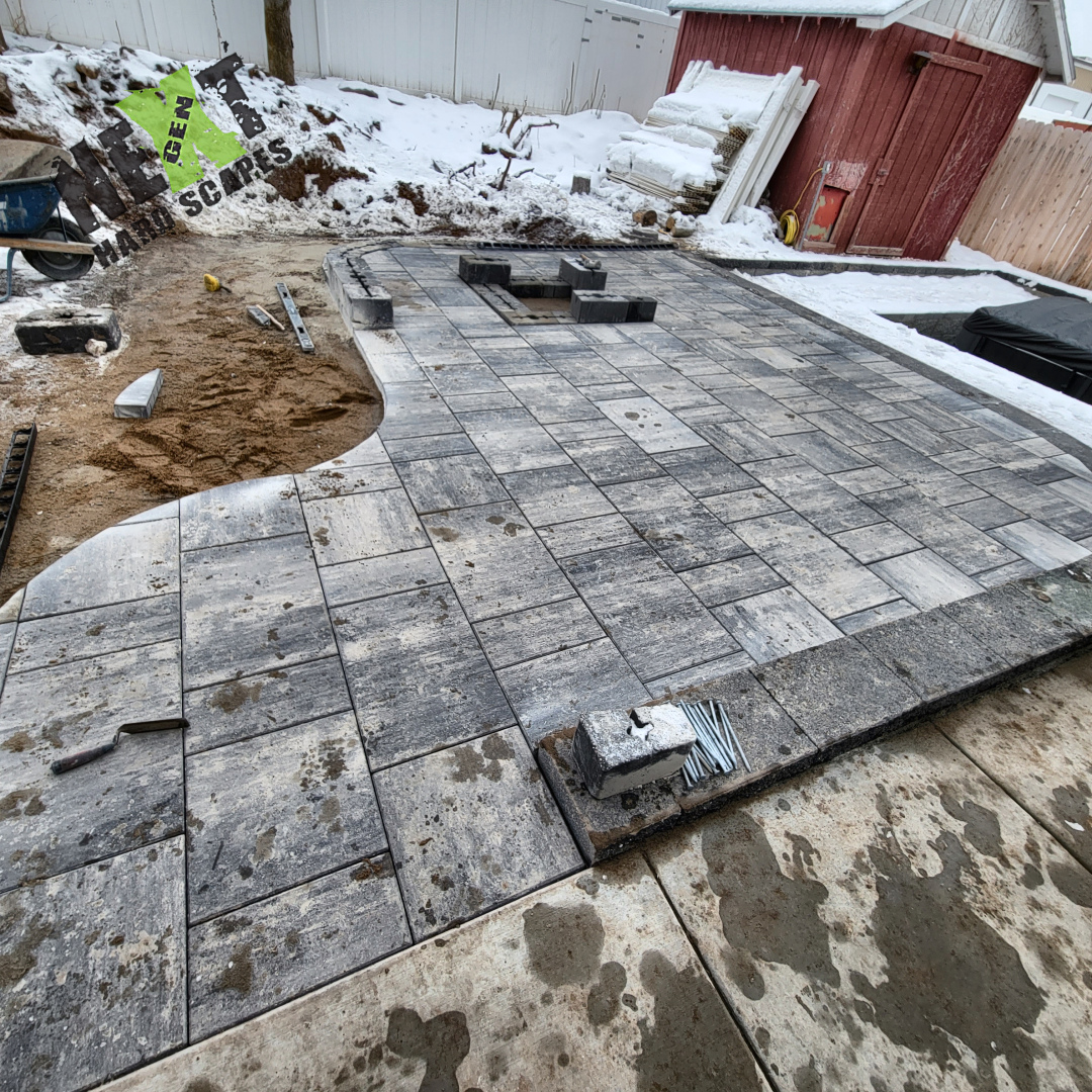 Paver patio area progressing with border stones set and space left for fire pit installation. Corners were cut to create a rounded flow to the fire pit. Paver patio area progressing with border stones set and space left for fire pit installation. Corners were cut to create a rounded flow to the fire pit.