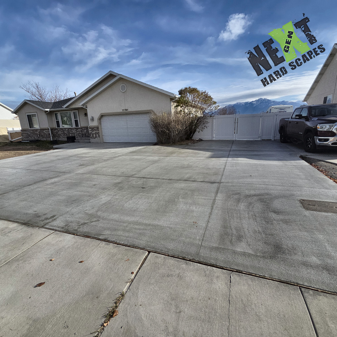 Completed driveway and side concrete area with the entrance clear, control joints defined, and flower and tree boxes integrated. Completed driveway and side concrete area with the entrance clear, control joints defined, and flower and tree boxes integrated.
