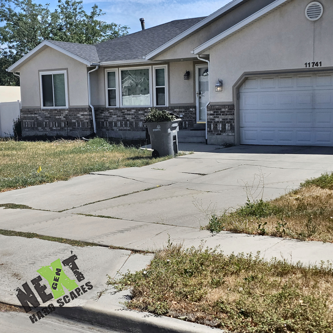 The deteriorated driveway approaching the garage with visible cracks and uneven surfaces indicating the need for replacement. The deteriorated driveway approaching the garage with visible cracks and uneven surfaces indicating the need for replacement.