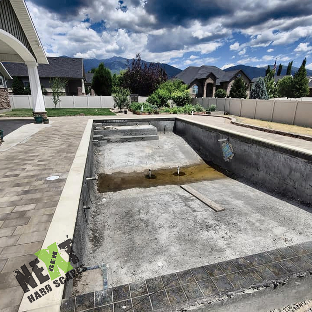 View of the excavated pool shell with concrete pool coping installed and prepared for final finishing. View of the excavated pool shell with concrete pool coping installed and prepared for final finishing.