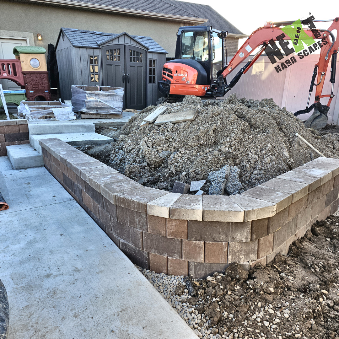 Interlocking block retaining wall built up at the patio edge with spoil and backfill still inside elevated playground as we finish grading. Interlocking block retaining wall built up at the patio edge with spoil and backfill still inside elevated playground as we finish grading.