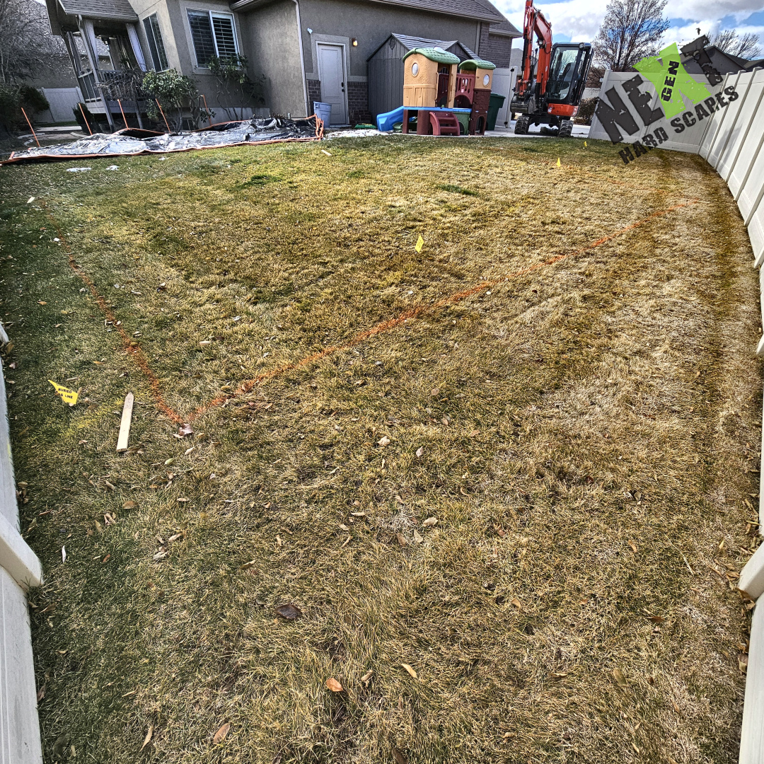 Orange layout string and survey flags mark the patio footprint on the existing lawn prior to demolition and excavation. Orange layout string and survey flags mark the patio footprint on the existing lawn prior to demolition and excavation.