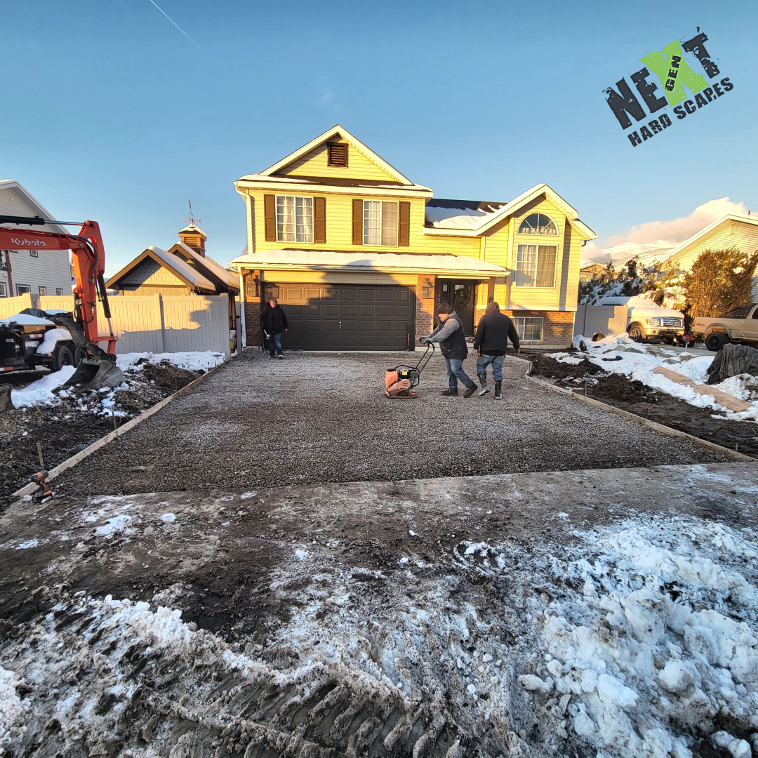 Existing driveway and walkway demolished with slabs removed and subgrade exposed at the garage apron ready for base work.