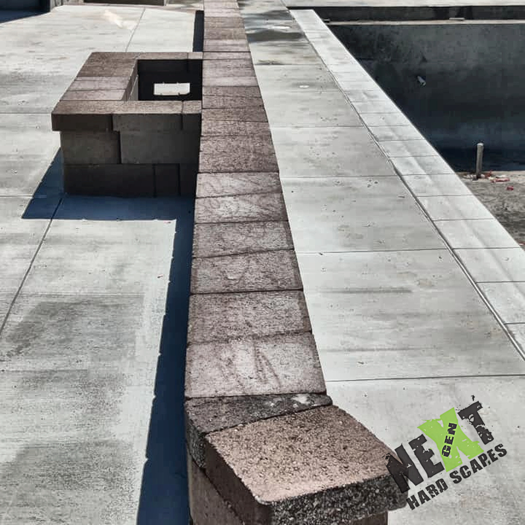 Continuous cap along the poolside edge with even spacing and a straight layout meeting the concrete deck joint.