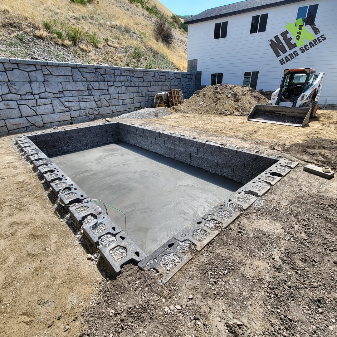 The recessed area starts with a flat concrete base and block retaining walls around the opening. This gives the swim spa a level, defined place to sit before the surrounding patio goes in. The recessed area starts with a flat concrete base and block retaining walls around the opening. This gives the swim spa a level, defined place to sit before the surrounding patio goes in.