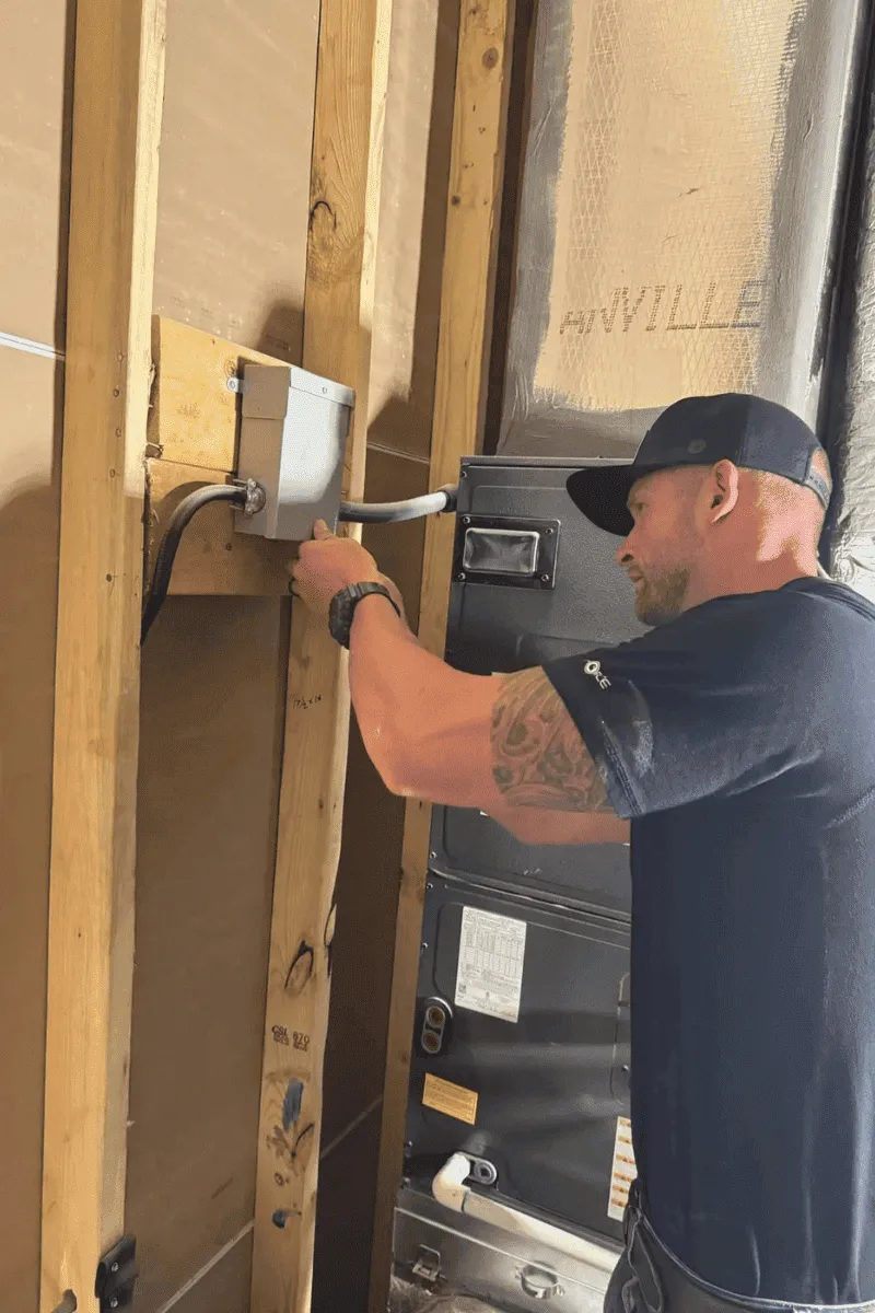 Sumner Electric Co technician safely wiring an advanced smart energy monitor into a residential breaker panel.