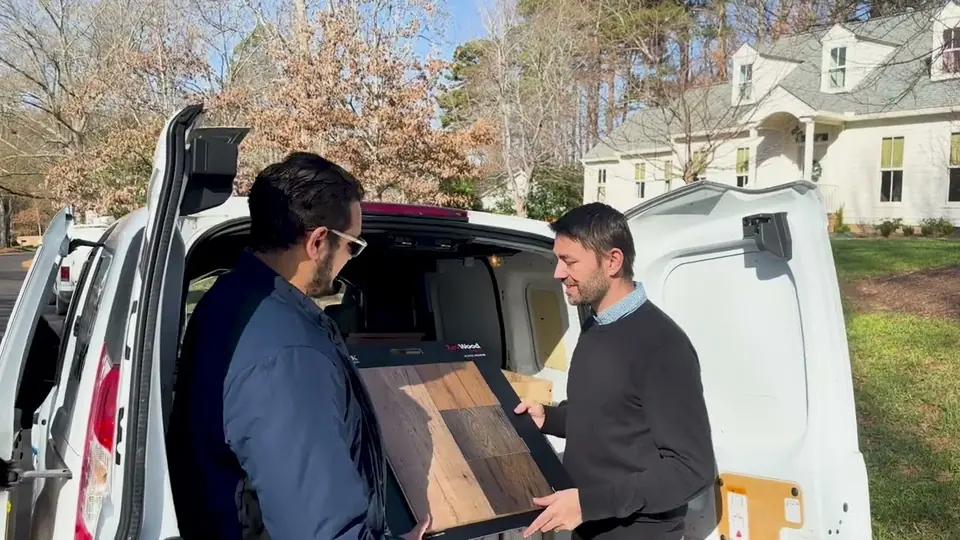 A Raleigh Flooring specialist showing hardwood samples to a homeowner at their home