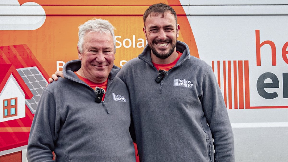 Two of the Helios Energy team in branded fleeces in front of their van