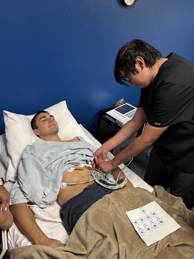 Instructor guiding student on EKG lead placement