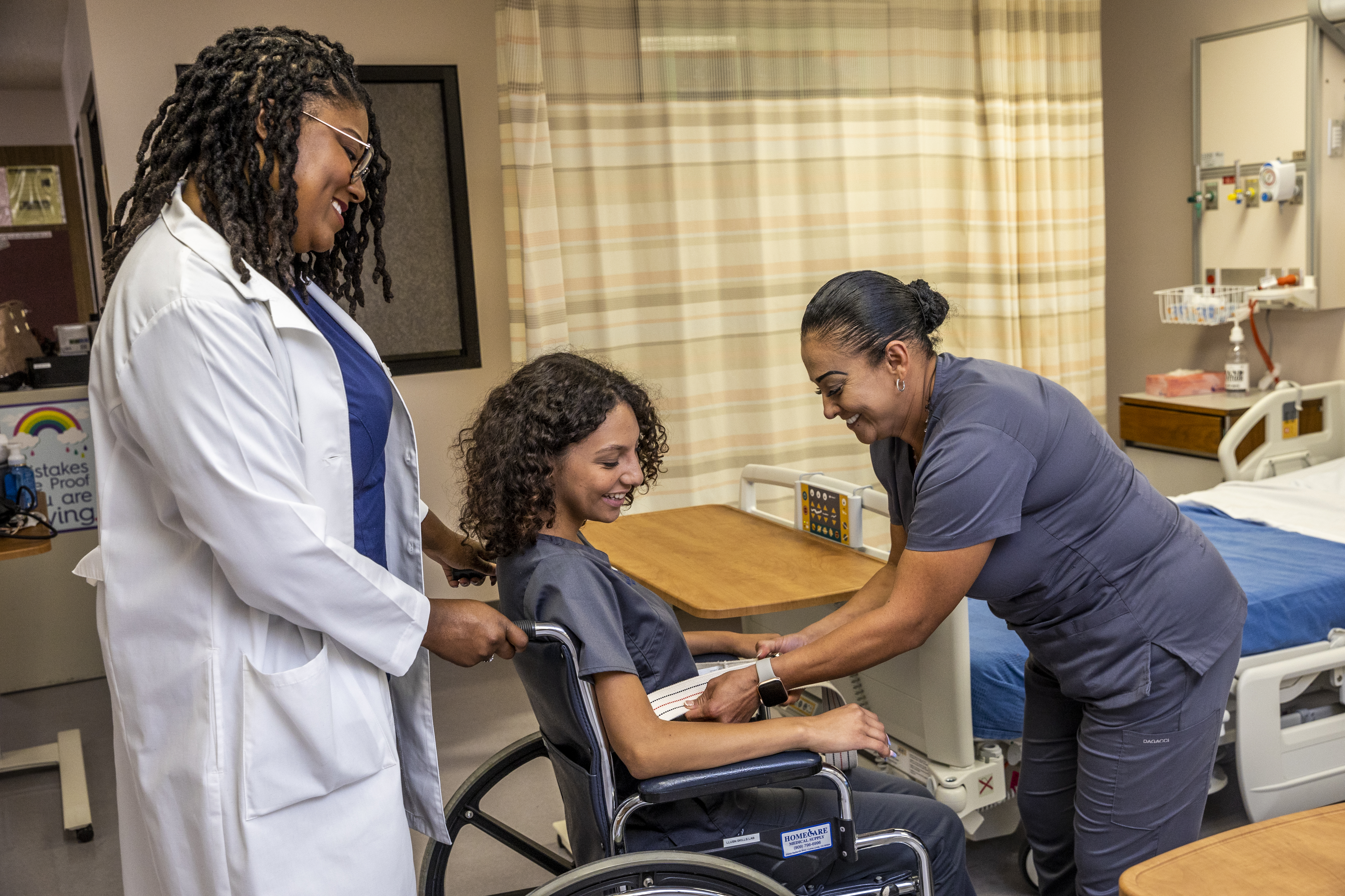 CNA students practicing safe wheelchair transport and assistance