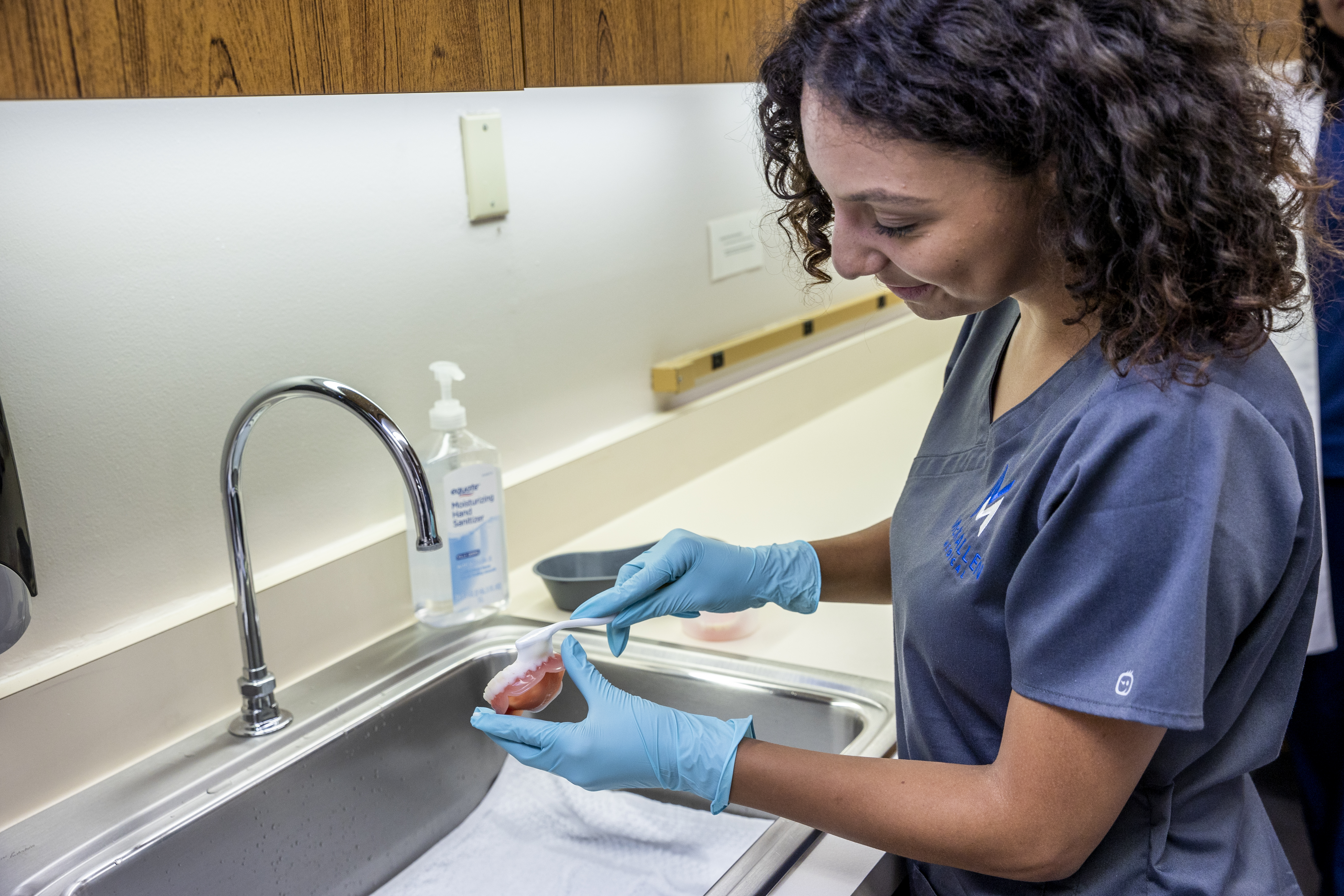 CNA student practicing proper sanitization at the sink