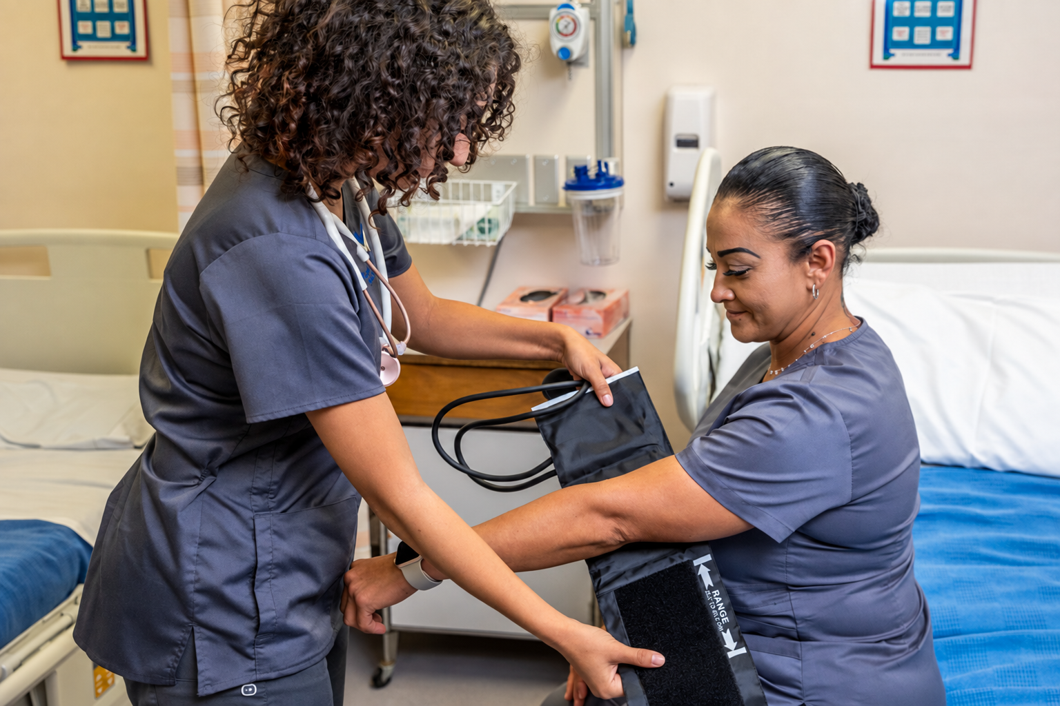 CNA student placing a blood pressure cuff on a peer