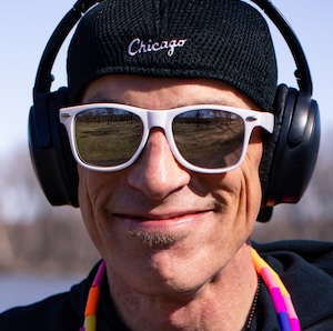 Dizzy Skips smiling with a jump rope, hat, sunglasses, and headphones