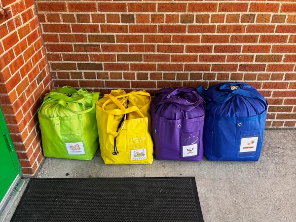 Four bagged laundry orders lined up against a brick wall
