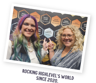 Cathy and Julie pointing at Funnel Gorgeous's spot as one of the first Diamond award recipients on the wall of SaaSpreneur awards at the 2020 Highlevel Level Up event.