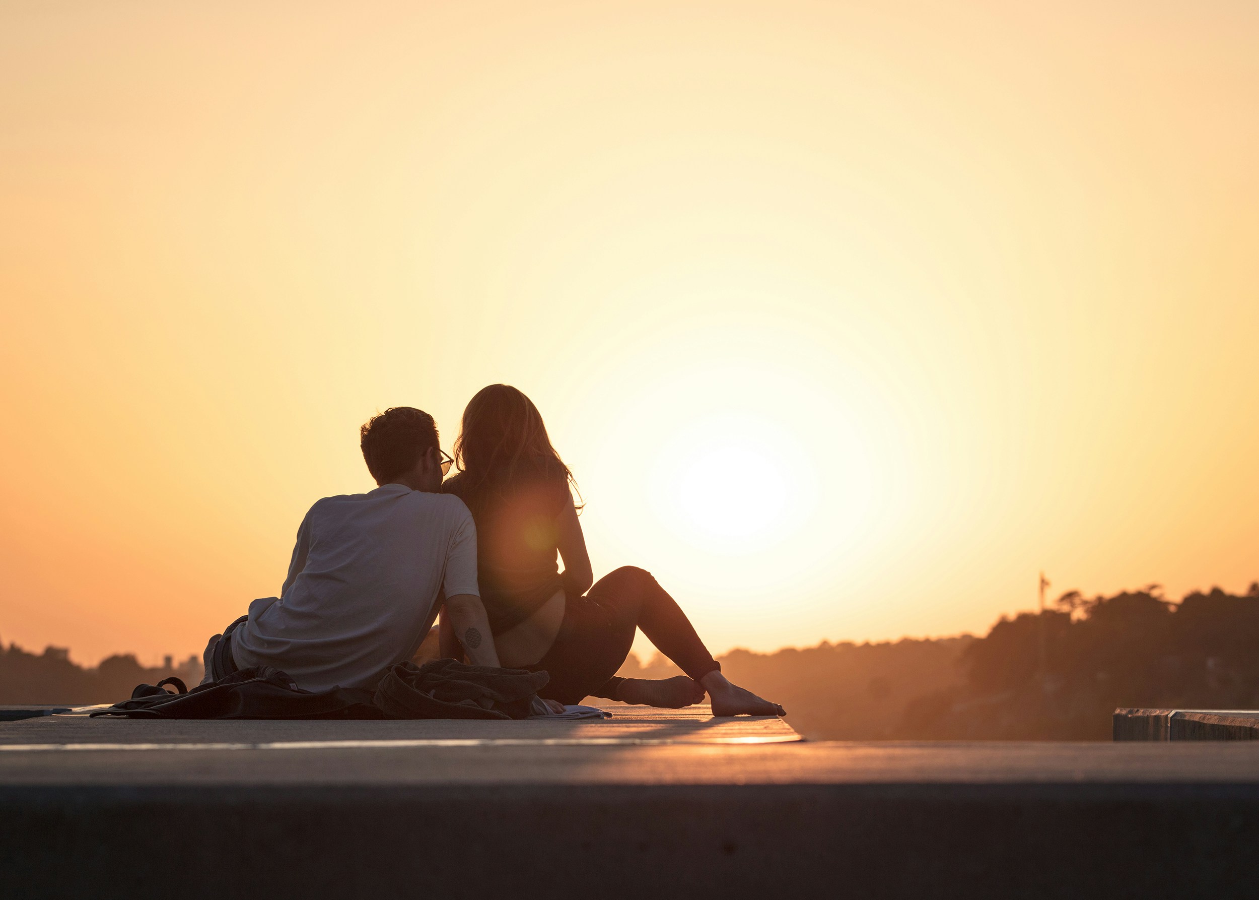 Couple sitting together looking at sunset